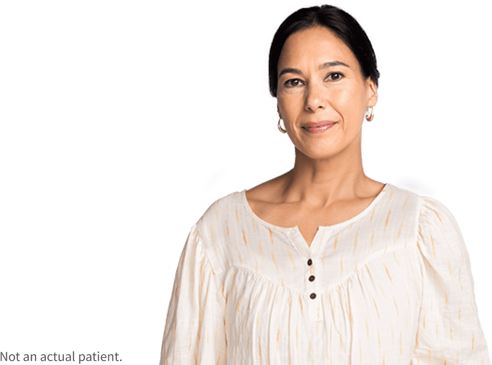 Woman looking directly at the camera and smiling softly. Not an actual patient.